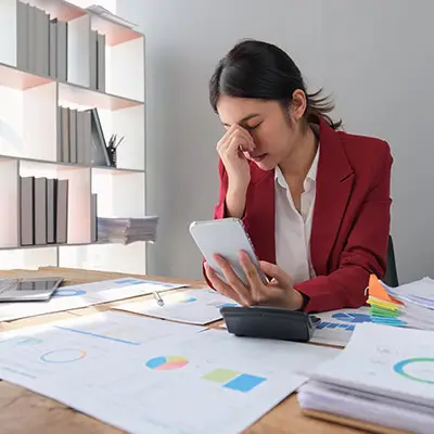 Image of stressed woman holding calculator