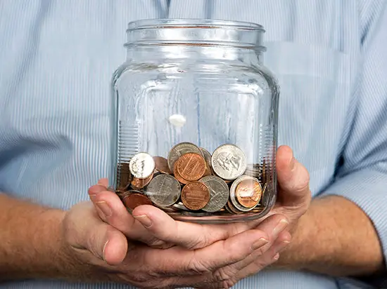 Image of man holding jar of coins